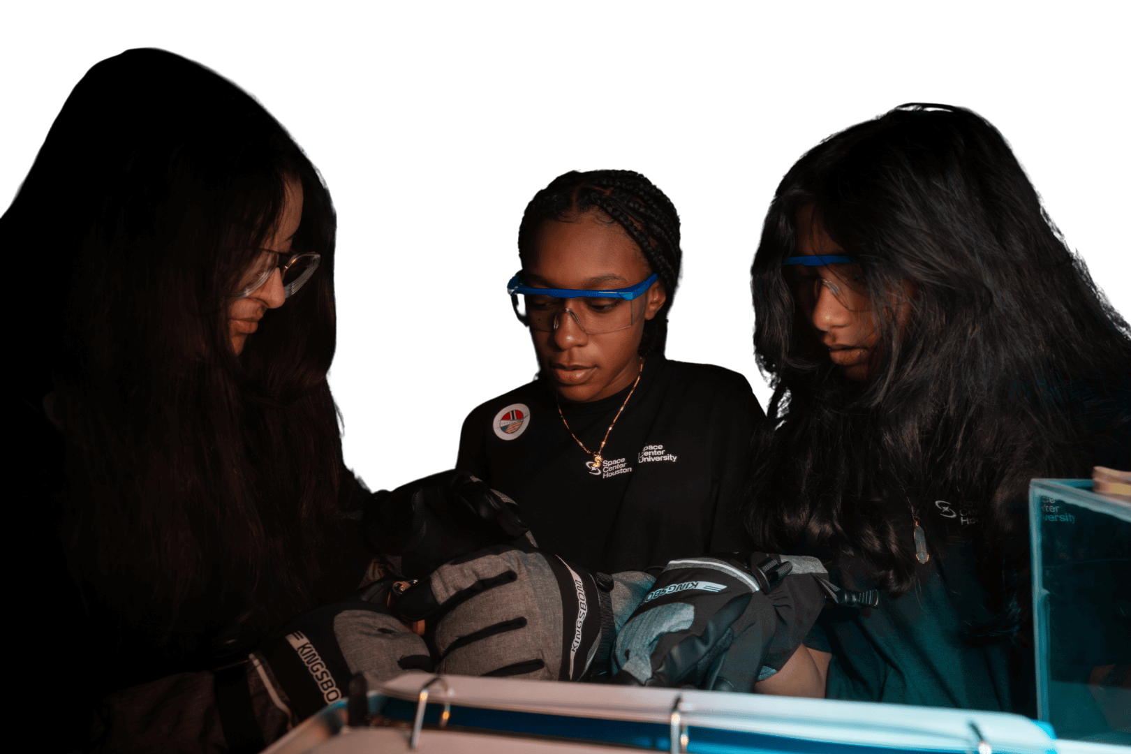 Three tween girls work together on a science experiment during one of the Space Center U's summer camp sessions in the Bay Area of Houston, TX.